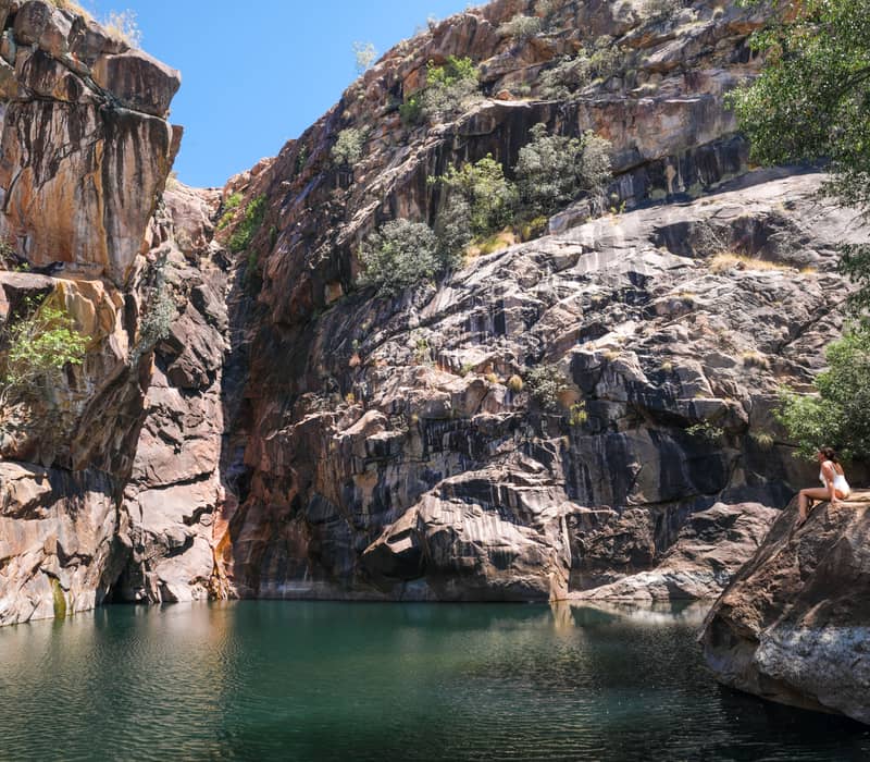 A visitor enjoys the tranquil surroundings of the Motor Car Falls plunge pool, a secluded swimming spot in the Yurmikmik region of Kakadu National Park.