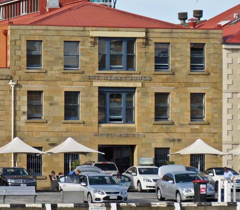 An opulent suite within The Henry Jones Art Hotel, featuring soaring Tasmanian Blackwood vaulted ceilings and original timber-lined walls. Located in a former jam factory on Hobart's waterfront, the room blends 19th-century industrial heritage with contem