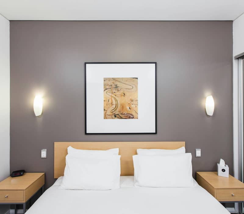 Illuminated entrance of Majestic Oasis Apartments at night with parking and signage